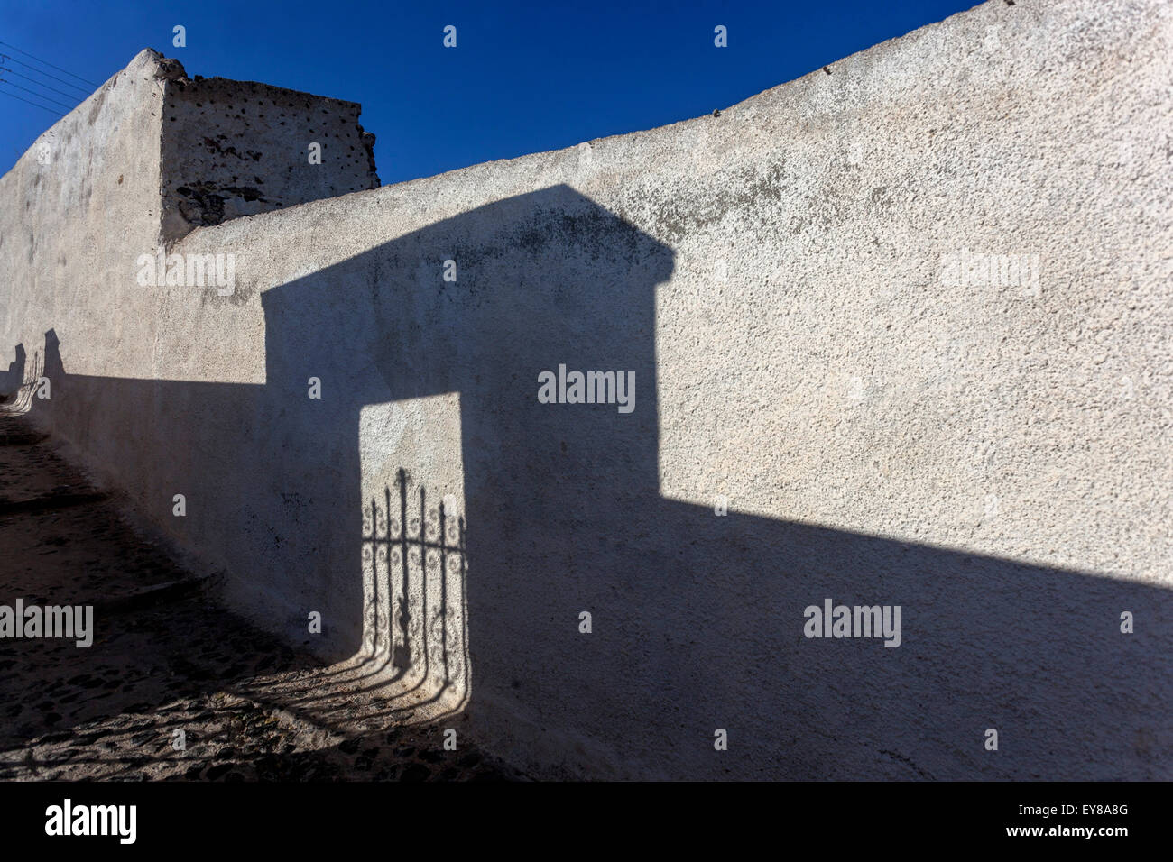 Schatten auf einer weiß getünchten Wand Santorini Street Greece Shadow White House Europe Greece Street Stockfoto