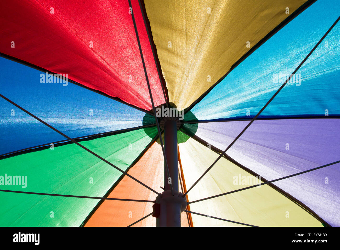 einen bunten Regenbogen farbige Sonnenschirm von unten gesehen Stockfoto