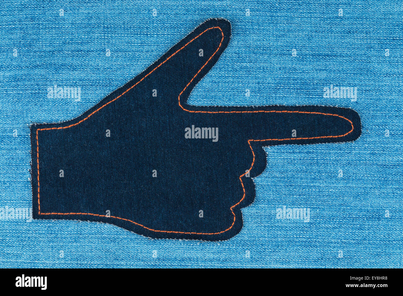 Hand in die Form, die ein Zeiger aus Denim-Jeans liegt auf Jeans Hintergrund, mit Platz für Ihren text Stockfoto