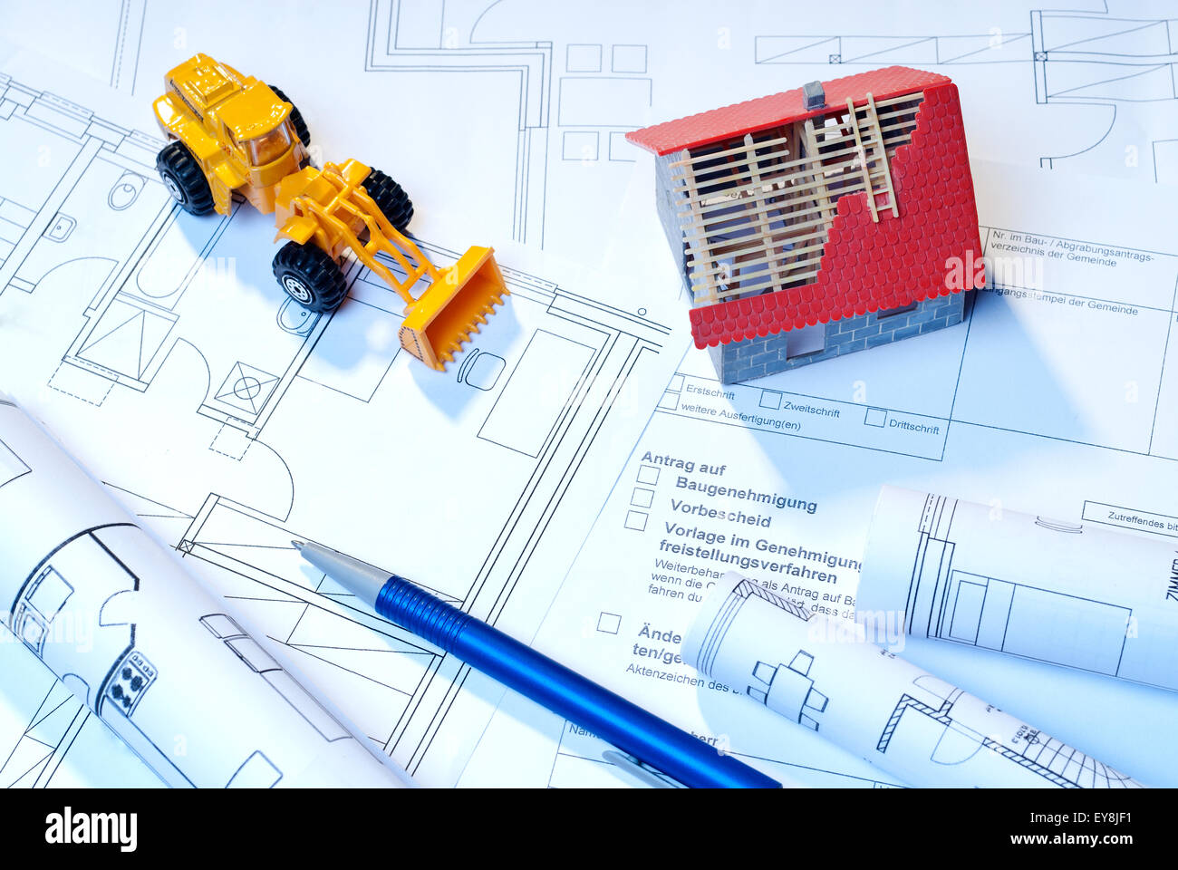 Baupläne, Architekturmodell und Spielzeug Bagger als Symbole für den Bau. Stockfoto