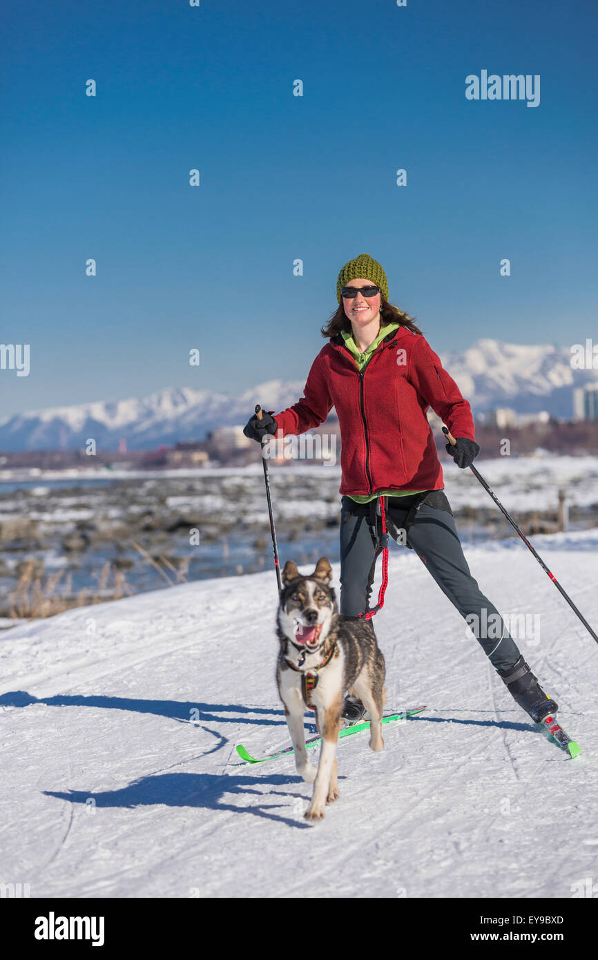 Eine junge Frau Skijors mit ihrem Alaska Husky Schlittenhunde unten Yunan Tony Knowles Coastal Trail, Anchorage, Alaska, USA. Stockfoto