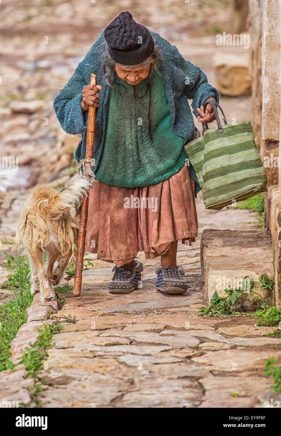 Eine ältere Frau geht auf den gepflasterten Gehweg; Toro Toro, Bolivien Stockfoto