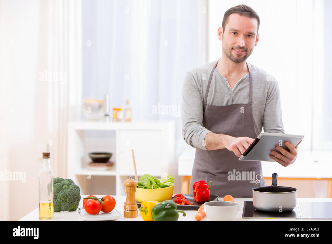 Blick auf einen jungen attraktiven Mann in einer Küche kochen Stockfoto