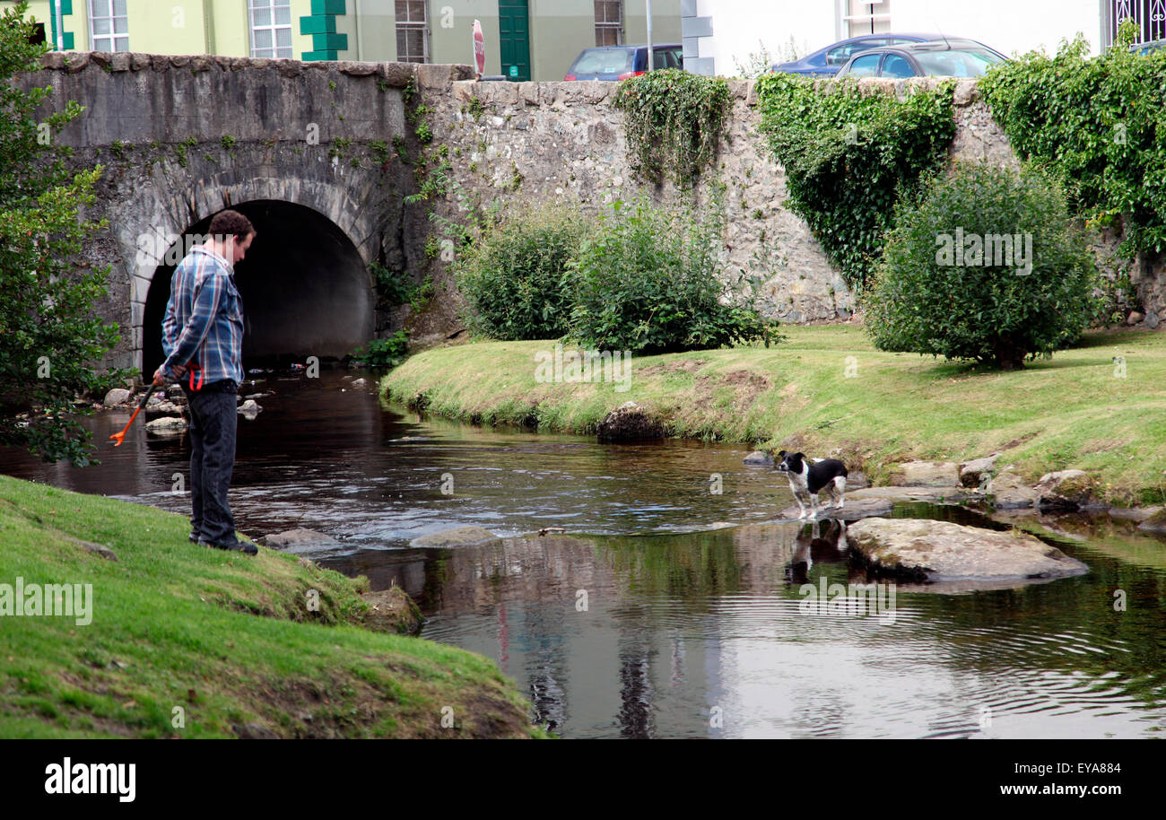 Mensch und Hund im Fluss Kikbroney, Rostrevor. Stockfoto