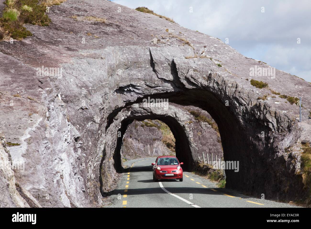 Von Hand geschnittenem Rock Tunnel über Straße; Bonane, County Kerry, Irland Stockfoto