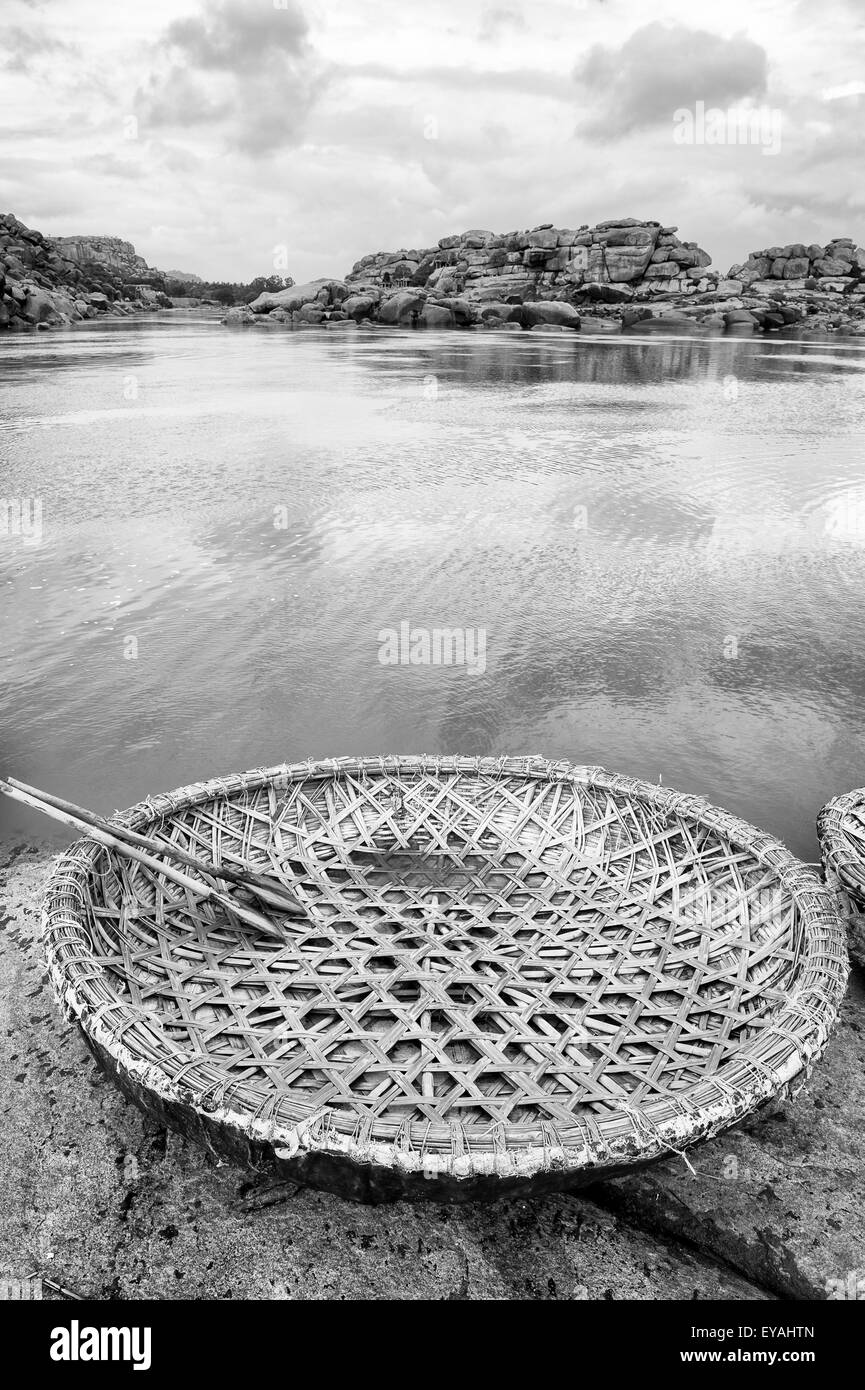 Rustikale Runde Coracle schwimmende Boot Korb aus Bambus und Kunststoff hergestellt neben dem Ghat am Fluss Tungabhadra in Hampi, Indien Stockfoto