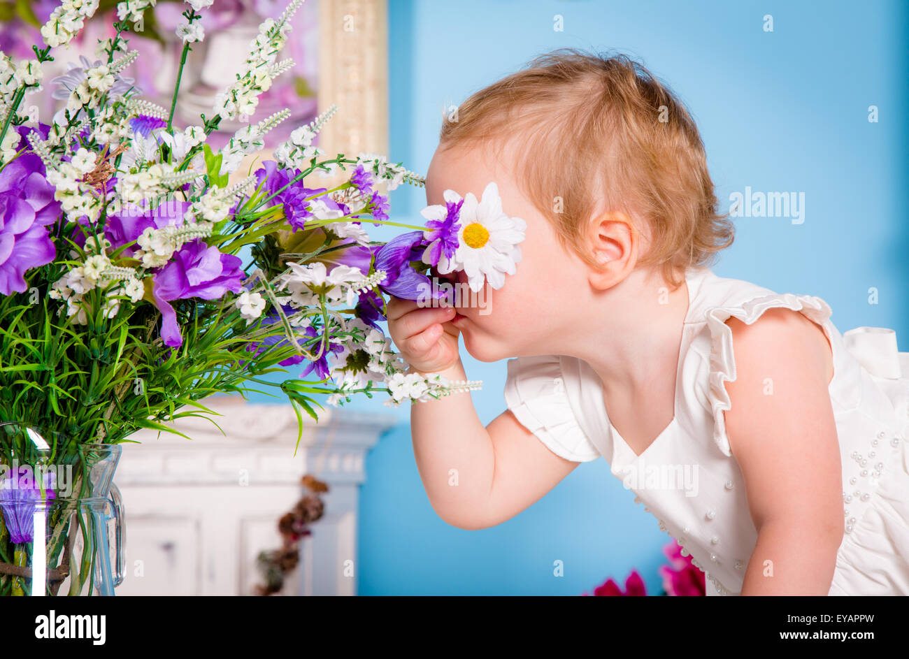 Kleines Mädchen riechen eine Blume Stockfoto