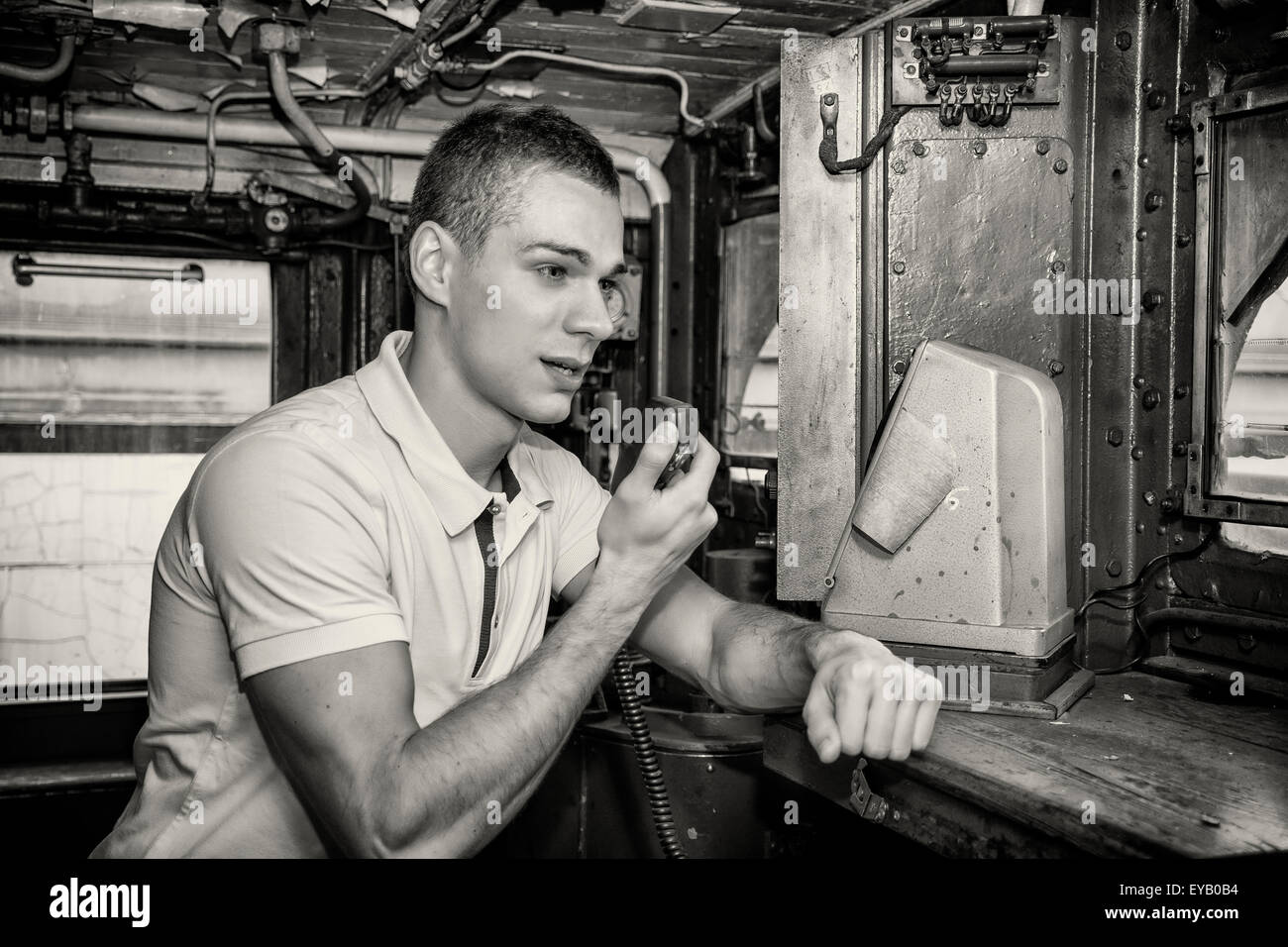 Schwarz / weiß Retro nahe altmodisch bis der junge Mann ins Funkgerät im Motor der alten sprechen Zug Lokomotive Stockfoto