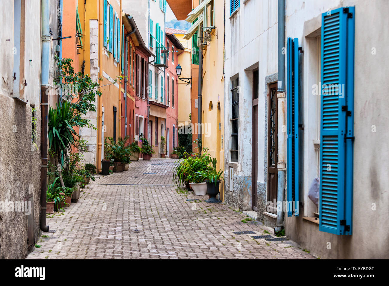 Gepflasterte Straße mit farbenfrohen Gebäuden und Topfpflanzen in mittelalterlichen Altstadt Villefranche-Sur-Mer an der Côte d ' Azur, Franken Stockfoto