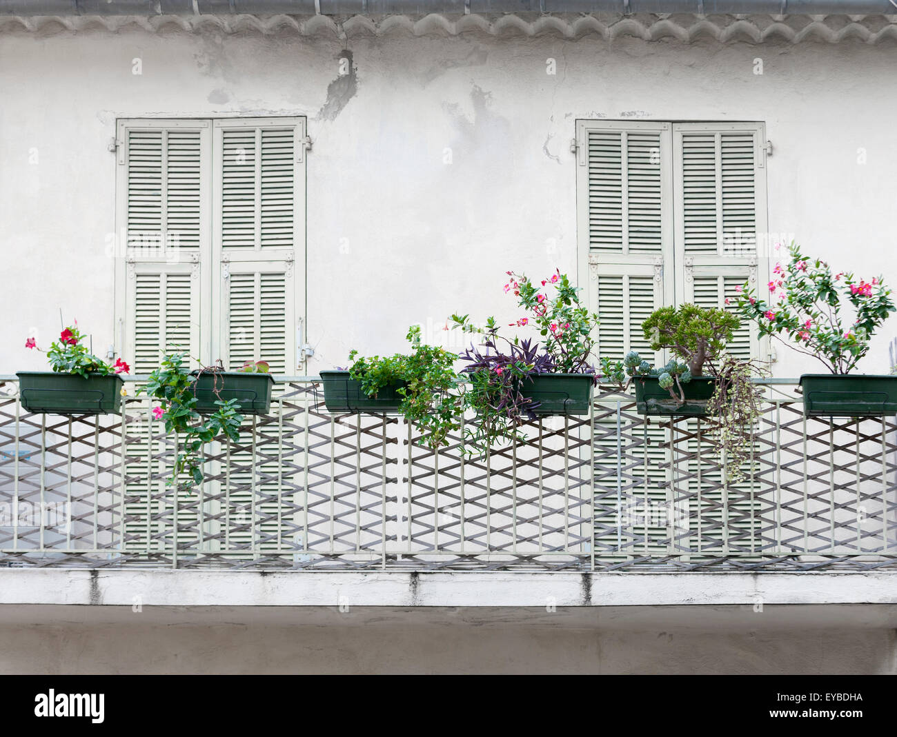 Französischer Balkon mit verschlossenen Türen und Blumenkästen auf alten Haus in Villefranche-Sur-Mer, Frankreich. Stockfoto