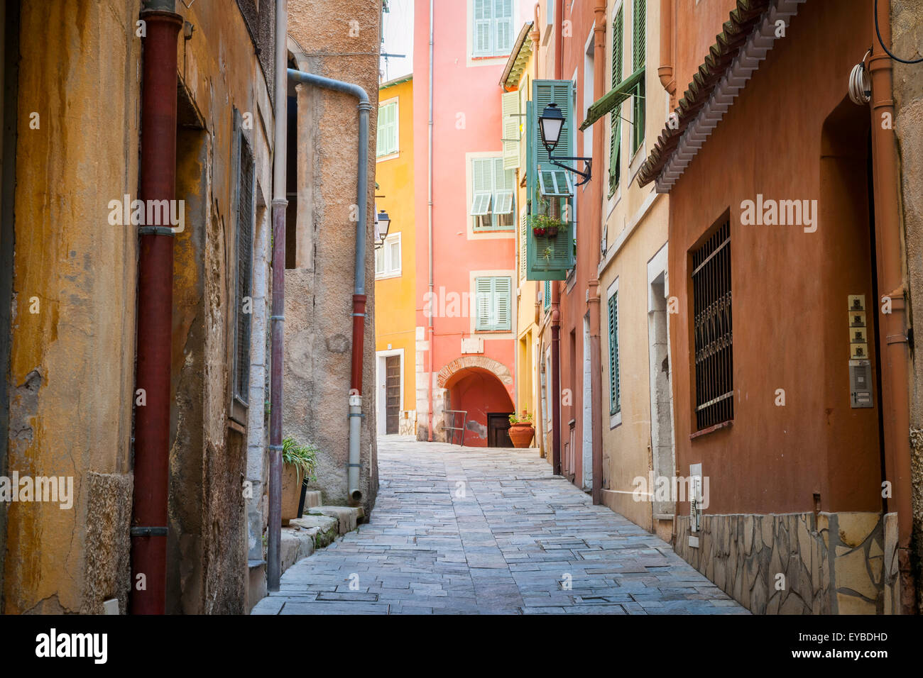 Schmale gepflasterte Straße mit hellen Gebäuden in der mittelalterlichen Stadt Villefranche-Sur-Mer an der Côte d ' Azur, Frankreich. Stockfoto