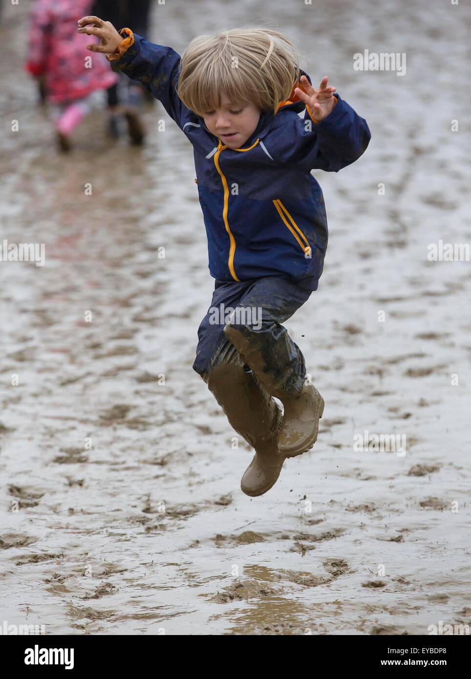 Malmesbury, Wiltshire, UK. 26. Juli 2015. Ein kleiner Junge springt in den Schlamm beim WOMAD-Festival in Charlton Park, Gloucestershire statt. 26. Juli 2015. Bildnachweis: Adam Gasson/Alamy Live-Nachrichten Stockfoto