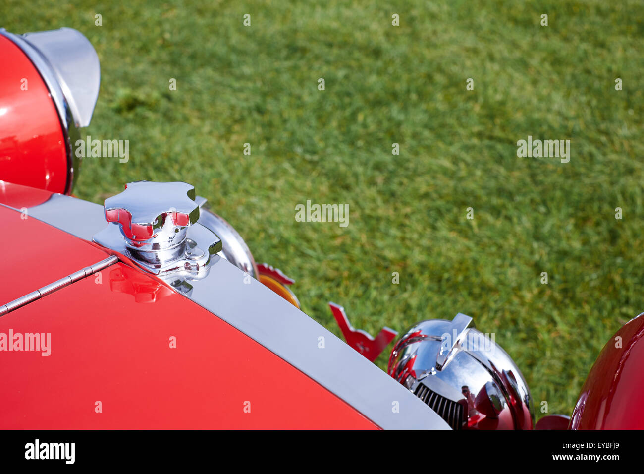 Front-End eines roten Autos zeigt Chrome gegen Grasgrün Stockfoto