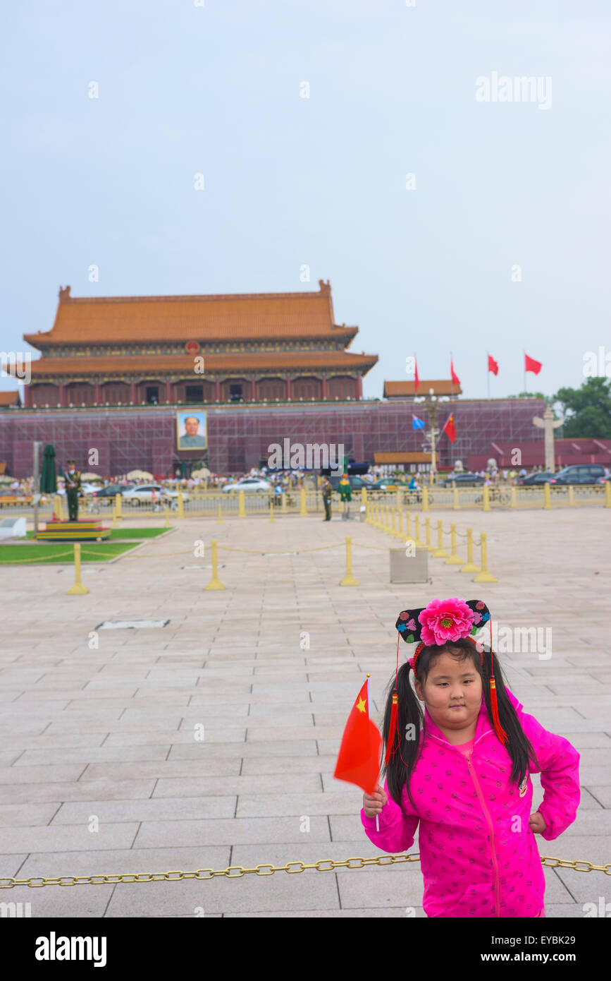 Chinesisches Mädchen, gekleidet-Up für ihren Besuch auf dem Platz des himmlischen Friedens in Peking, Flagge die vor Eingang zur verbotenen Stadt Stockfoto