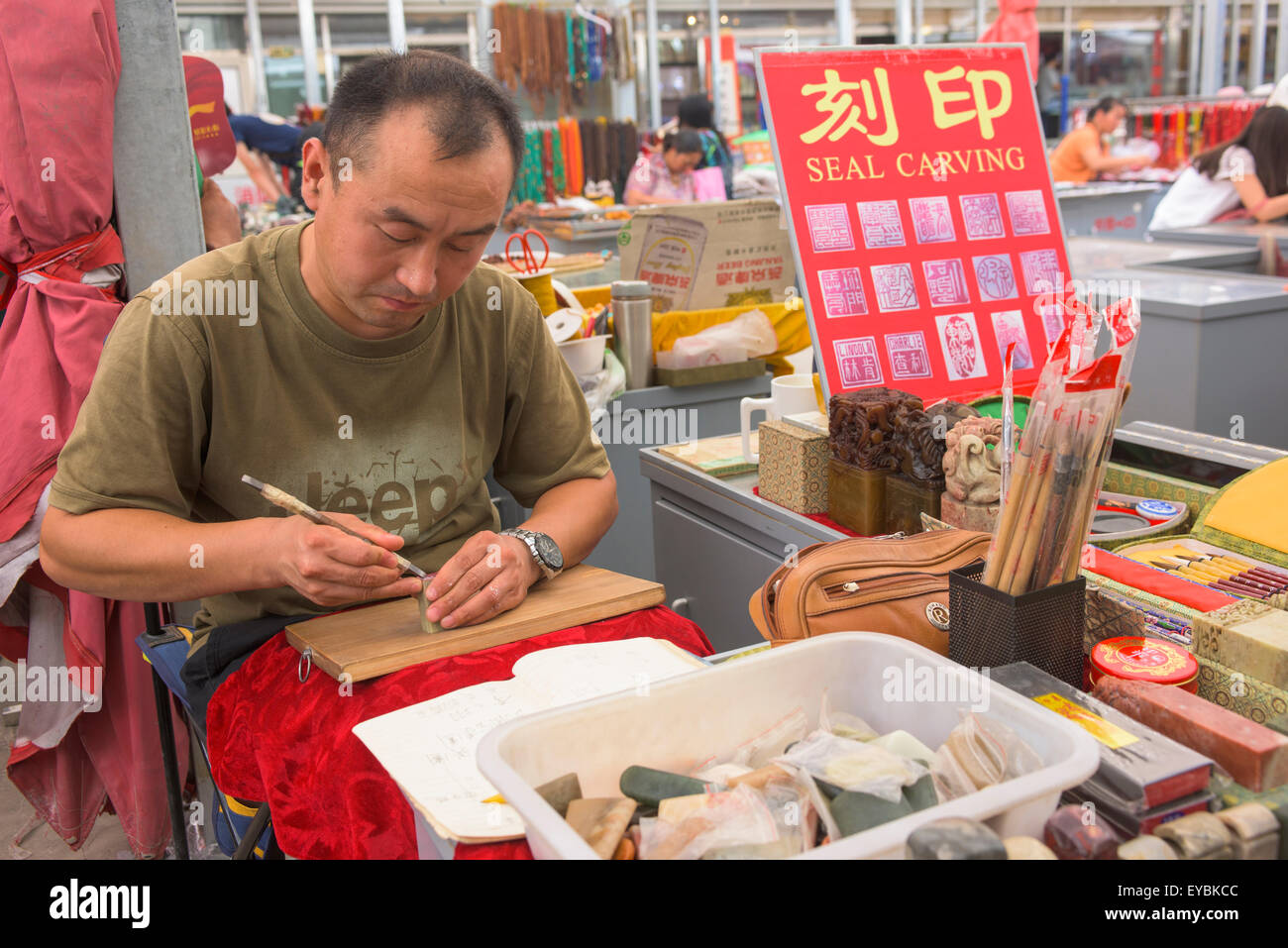 Mann schnitzen Namen Dichtung am Antiquitätenmarkt, Peking, China - Juli 2015 Stockfoto