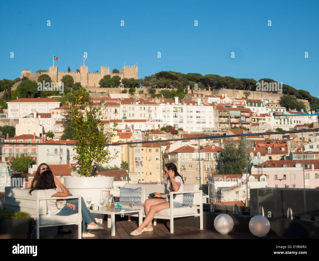 Frauen im Chat auf einer Terrasse in Lissabon Innenstadt mit Castle Hill im Hintergrund Stockfoto