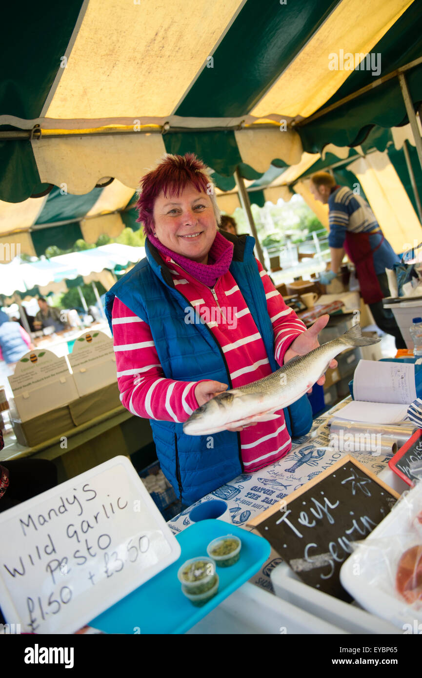 Eine Frau Standbesitzer Verkauf vor Ort frisch gefangen Wolfsbarsch auf St. Dogmaels Lebensmittelmarkt, West Wales UK Stockfoto