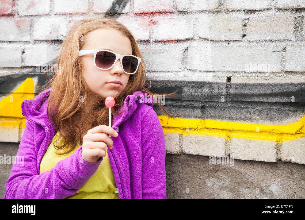 Blonde Teenager-Mädchen mit Lollipop, vertikale urban Outdoor-Porträt Stockfoto
