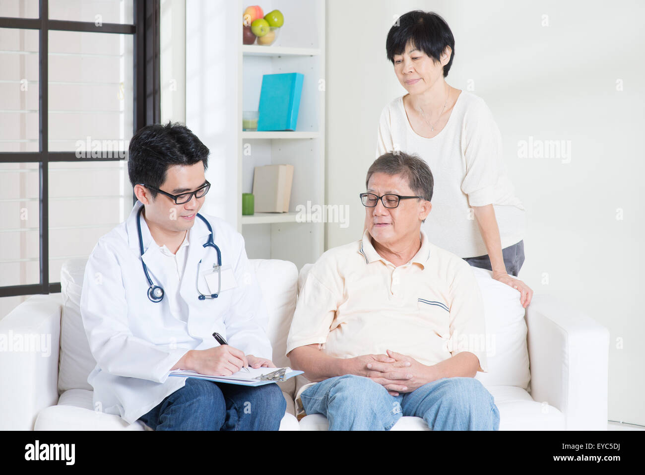 Arzt und Patient. Asiatische älteres paar Familie Arzt konsultieren, auf Sofa sitzen. Senior Rentner drinnen Lebensweise. Stockfoto