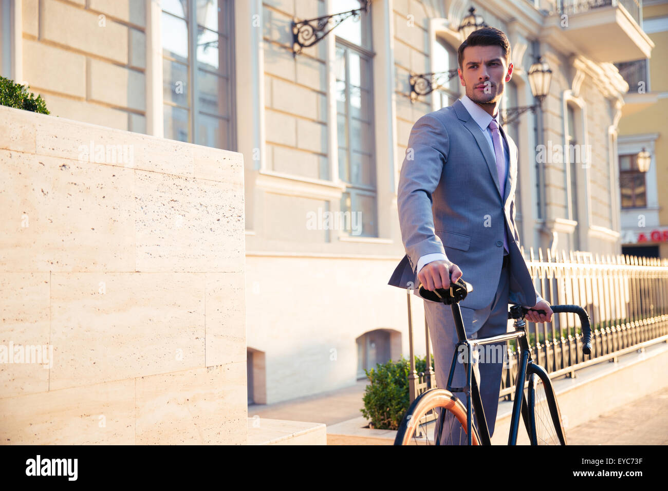 Porträt eines zuversichtlich Geschäftsmann stehend mit dem Fahrrad in der Altstadt und wegsehen Stockfoto