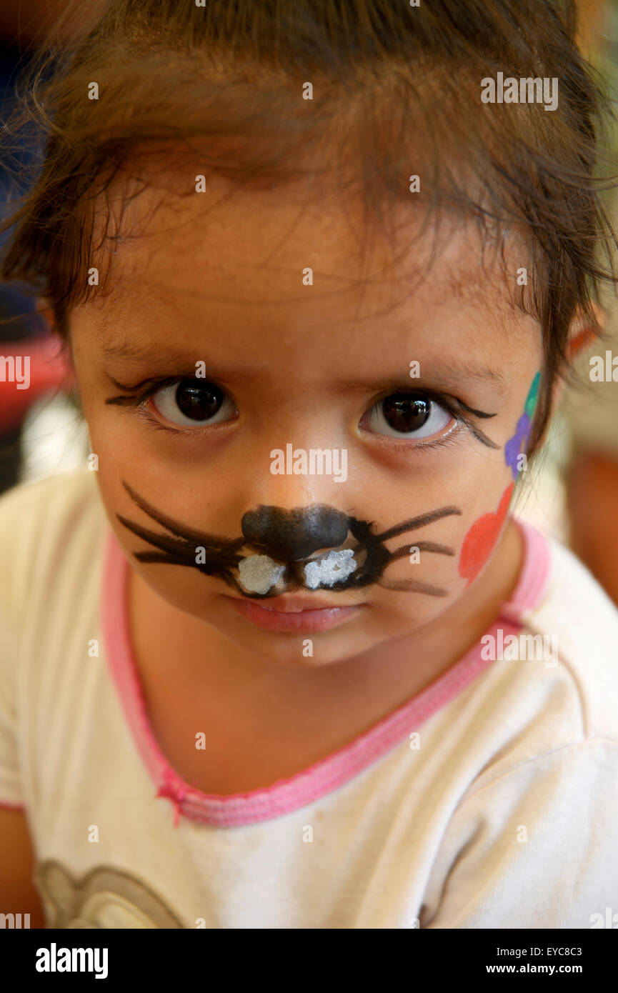 Mädchen mit Gesicht gemalt, wie eine Katze auf einem Kinderfest, Friedensinitiative der Polizei und der katholischen Kirche in den Slums von Stockfoto