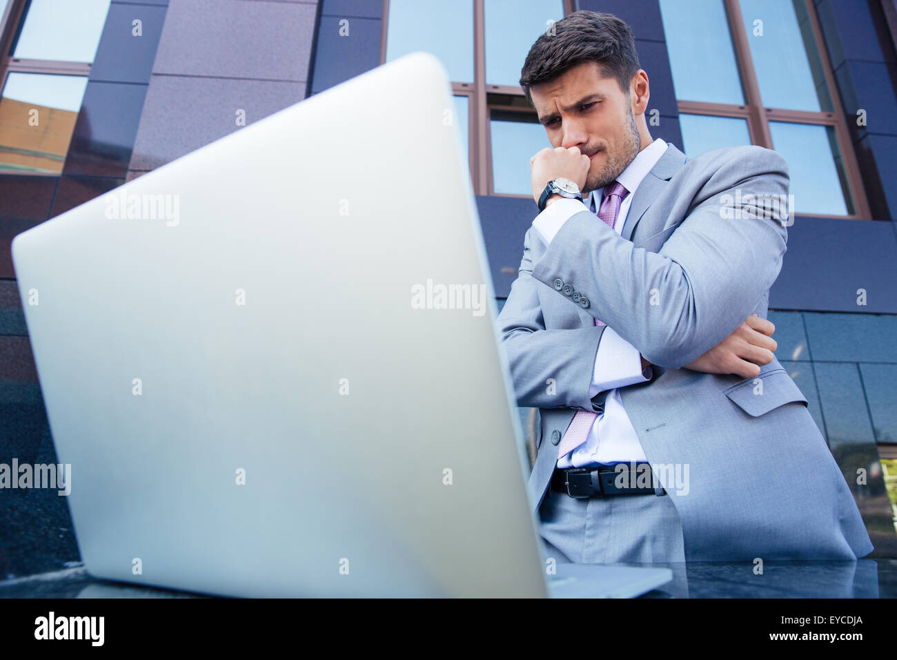 Porträt eines besorgt Geschäftsmannes betrachten Laptop im freien Stockfoto