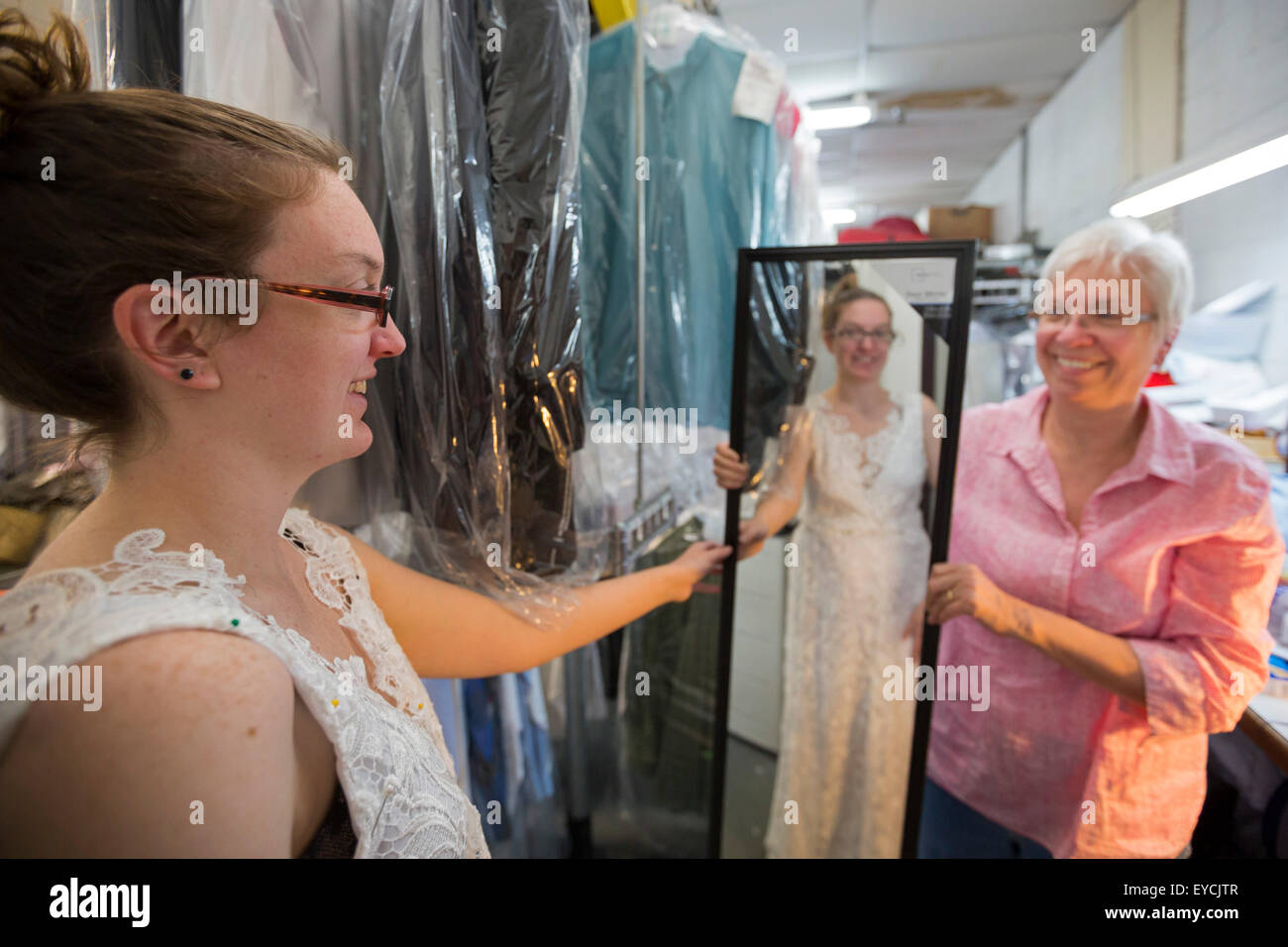 Broomfield, Colorado - eine junge Frau versucht auf ihrem unvollendeten Hochzeit Kleid wie ihre Mutter Uhren. Stockfoto