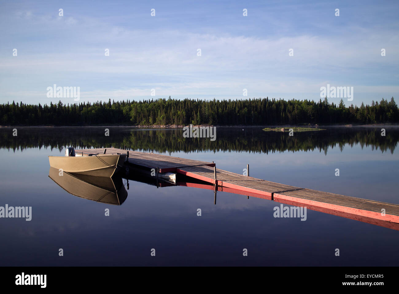 Holzsteg mit kleinen Boot an einem ruhigen Morgen Stockfoto