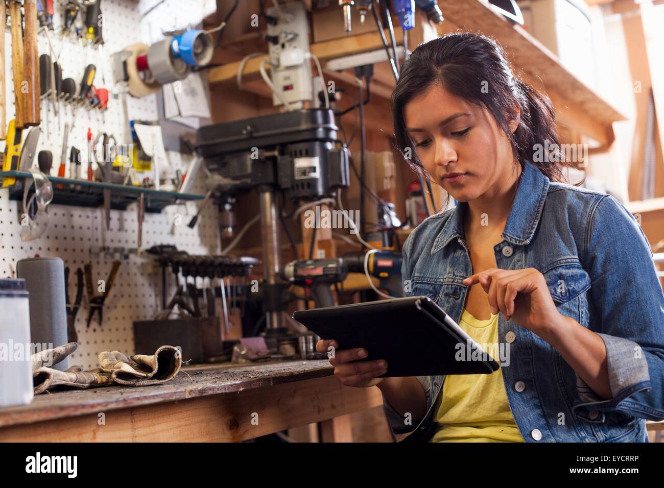 Weibliche Mechaniker mit digital-Tablette in Werkstatt Stockfoto