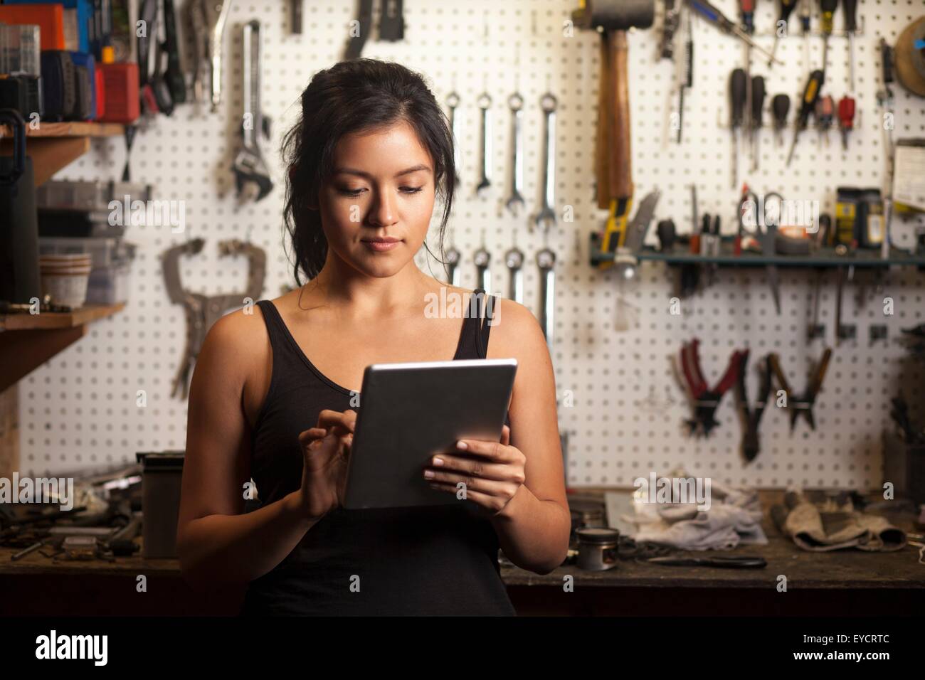 Weibliche Mechaniker in der Werkstatt, mit digital-Tablette Stockfoto