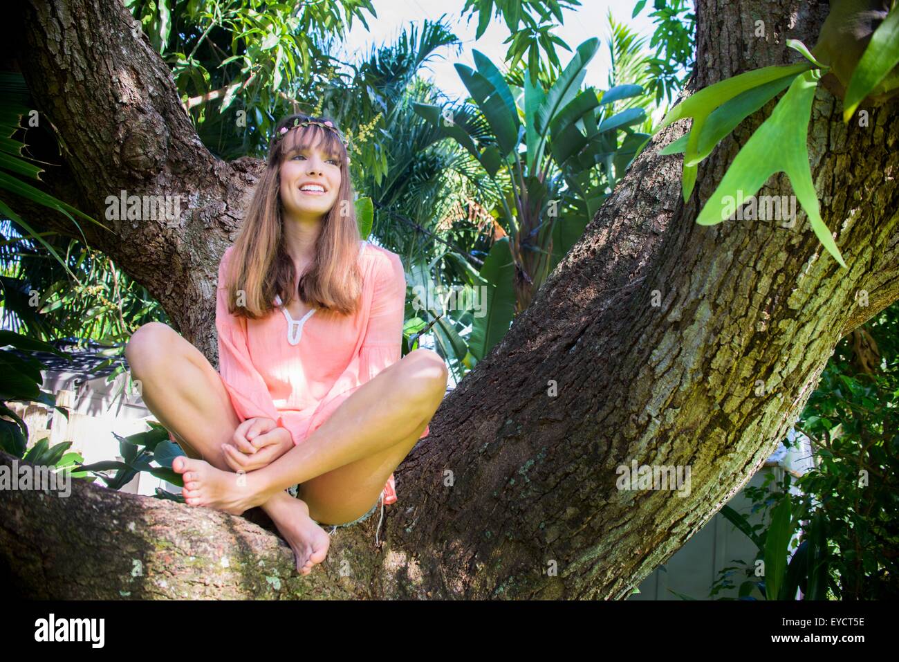 Porträt der jungen Frau mit Blick vom Baum Stockfoto