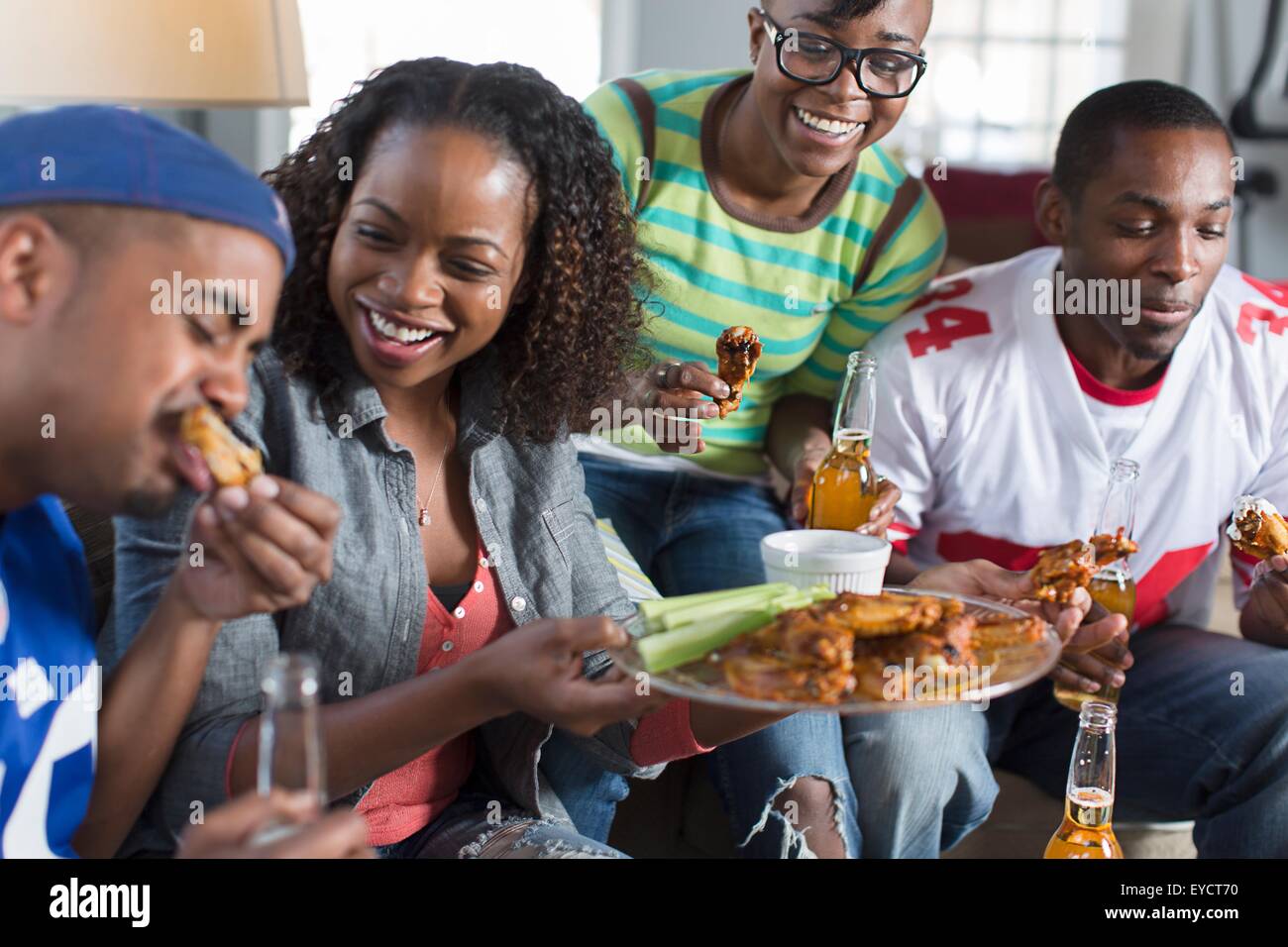 Gruppe von Erwachsenen Freunden Essen zum mitnehmen auf Sofa im Wohnzimmer Stockfoto
