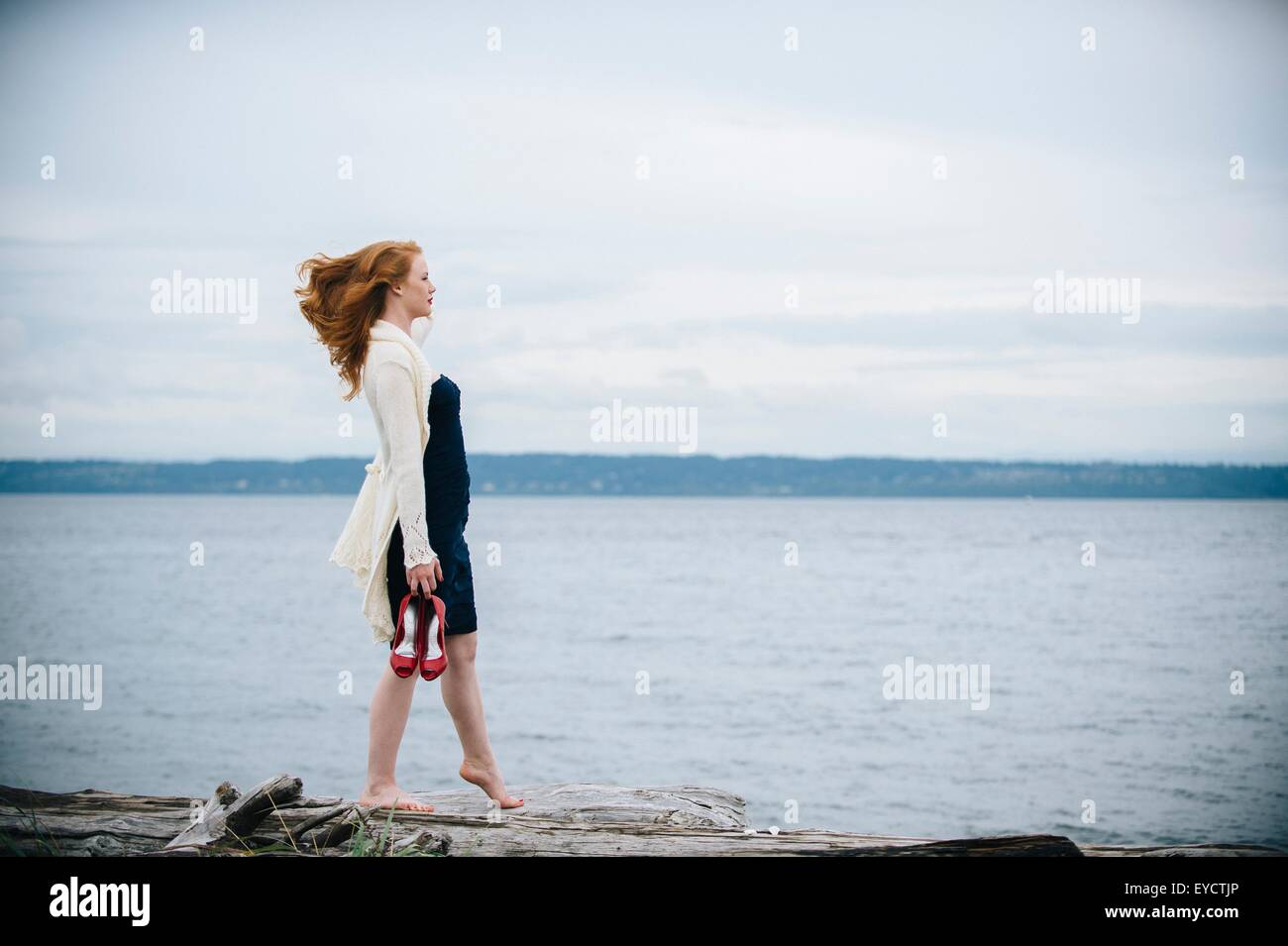 Junge Frau am Strand mit Blick auf Meer, Bainbridge Island, Washington State, USA Stockfoto