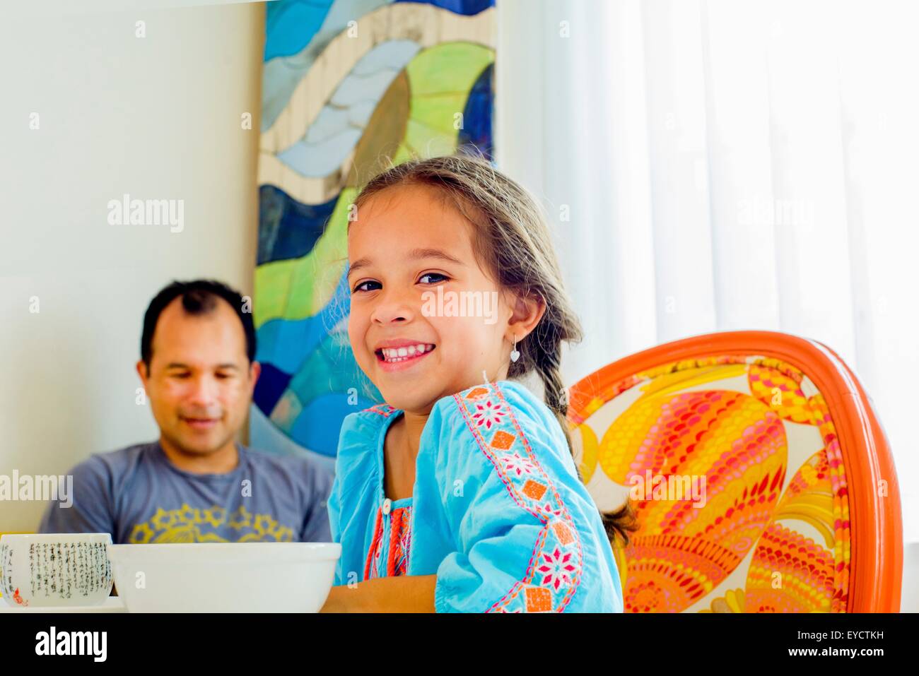 Porträt eines Mädchens mit Vater am Tisch sitzen Stockfoto