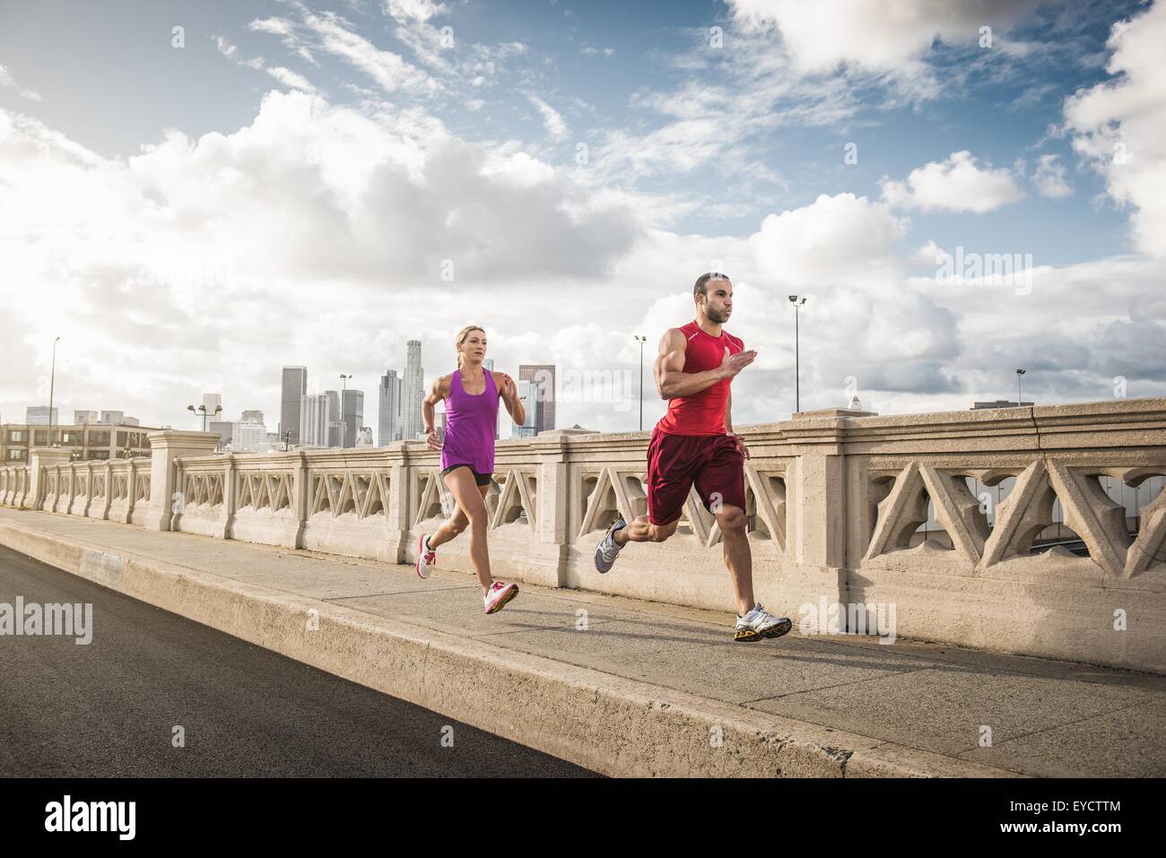 Männliche und weibliche Läufer laufen über Brücke, Los Angeles, Kalifornien, USA Stockfoto