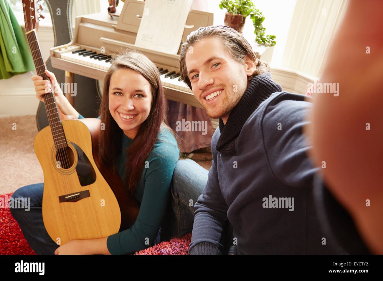Junger Mann unter Selfie mit Gitarrist Freundin Stockfoto