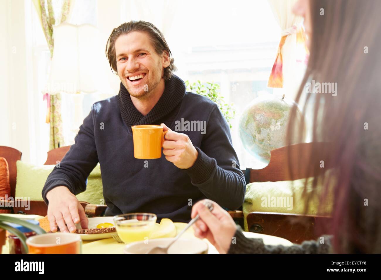 Über Schulter Blick des jungen Menschen trinken Kaffee am Frühstückstisch Stockfoto