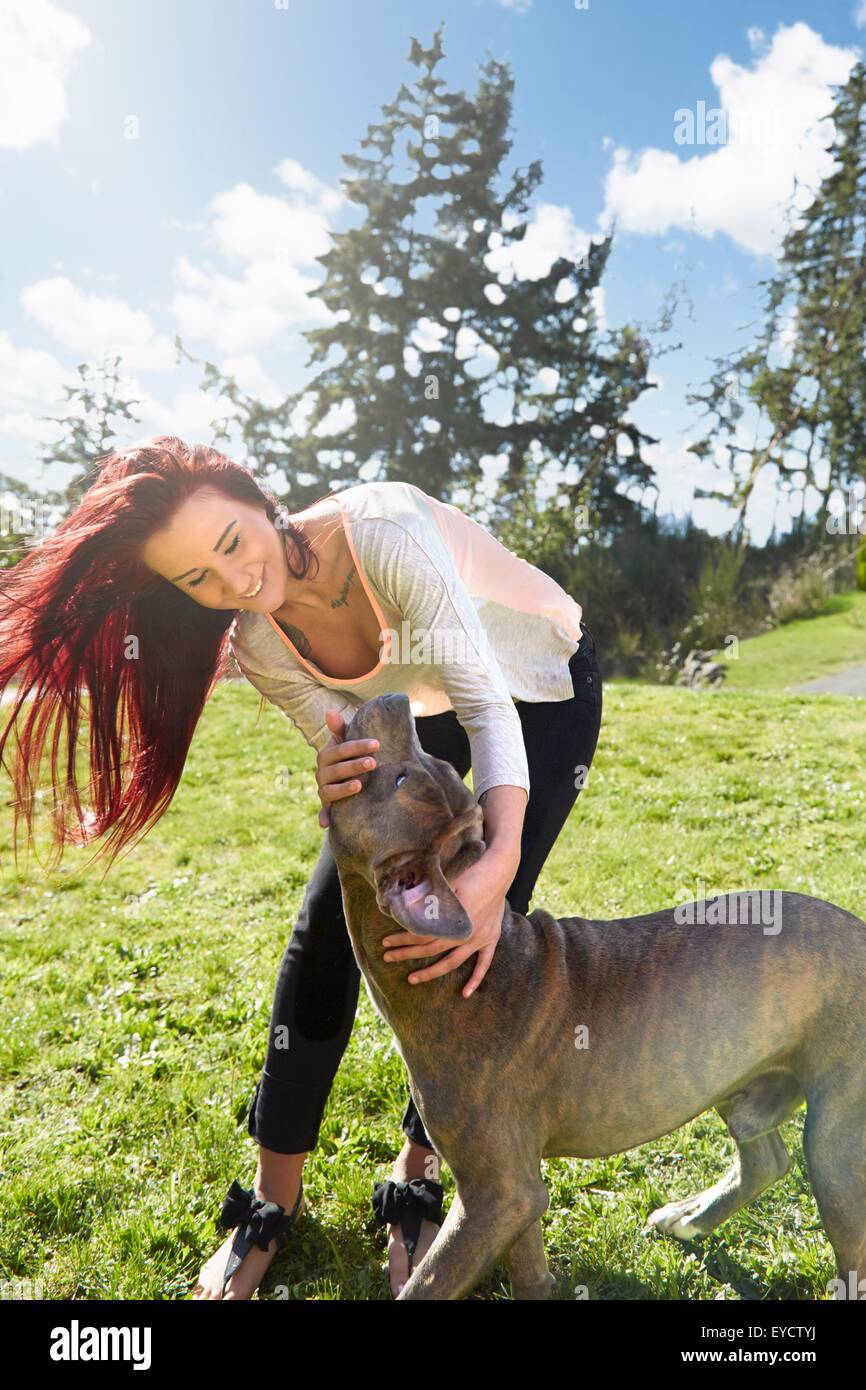 Junge Frau streicheln ihren Hund im park Stockfoto