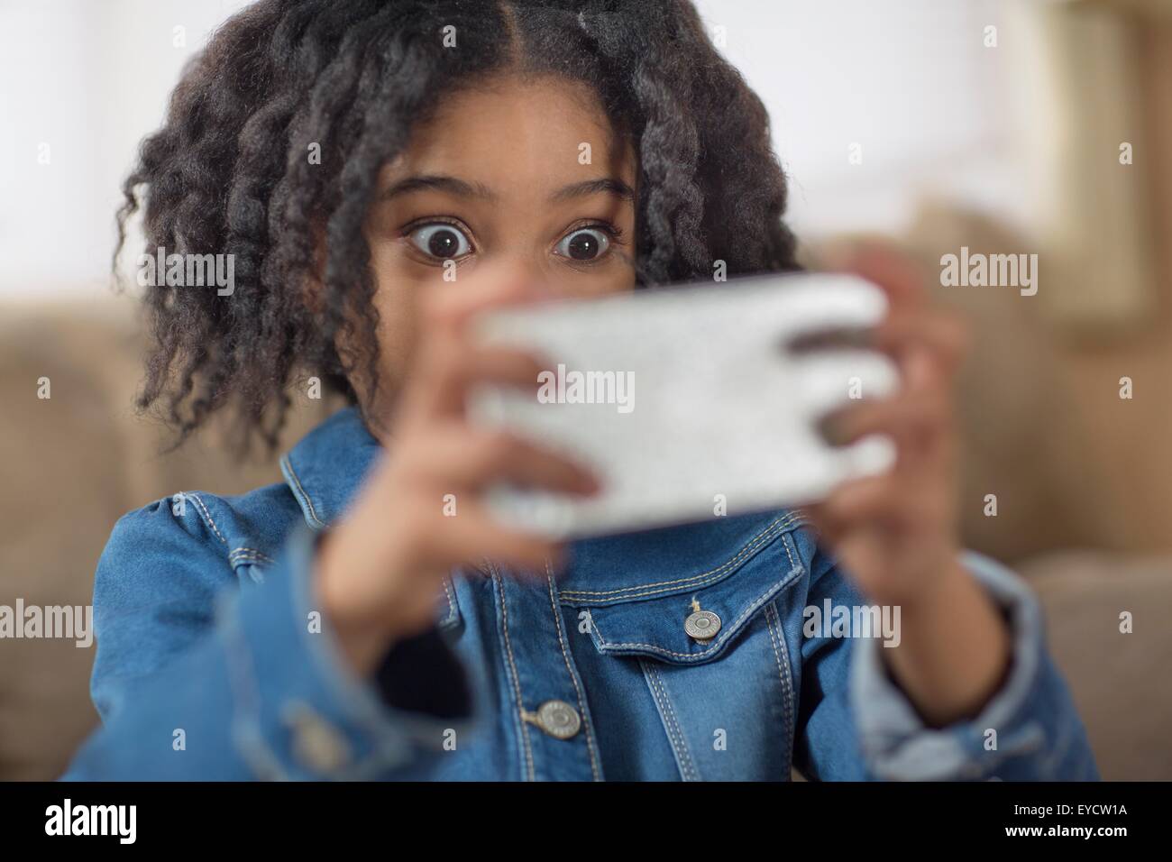Nahaufnahme von niedlichen Mädchen auf der Suche für Smartphone Selfie überrascht Stockfoto