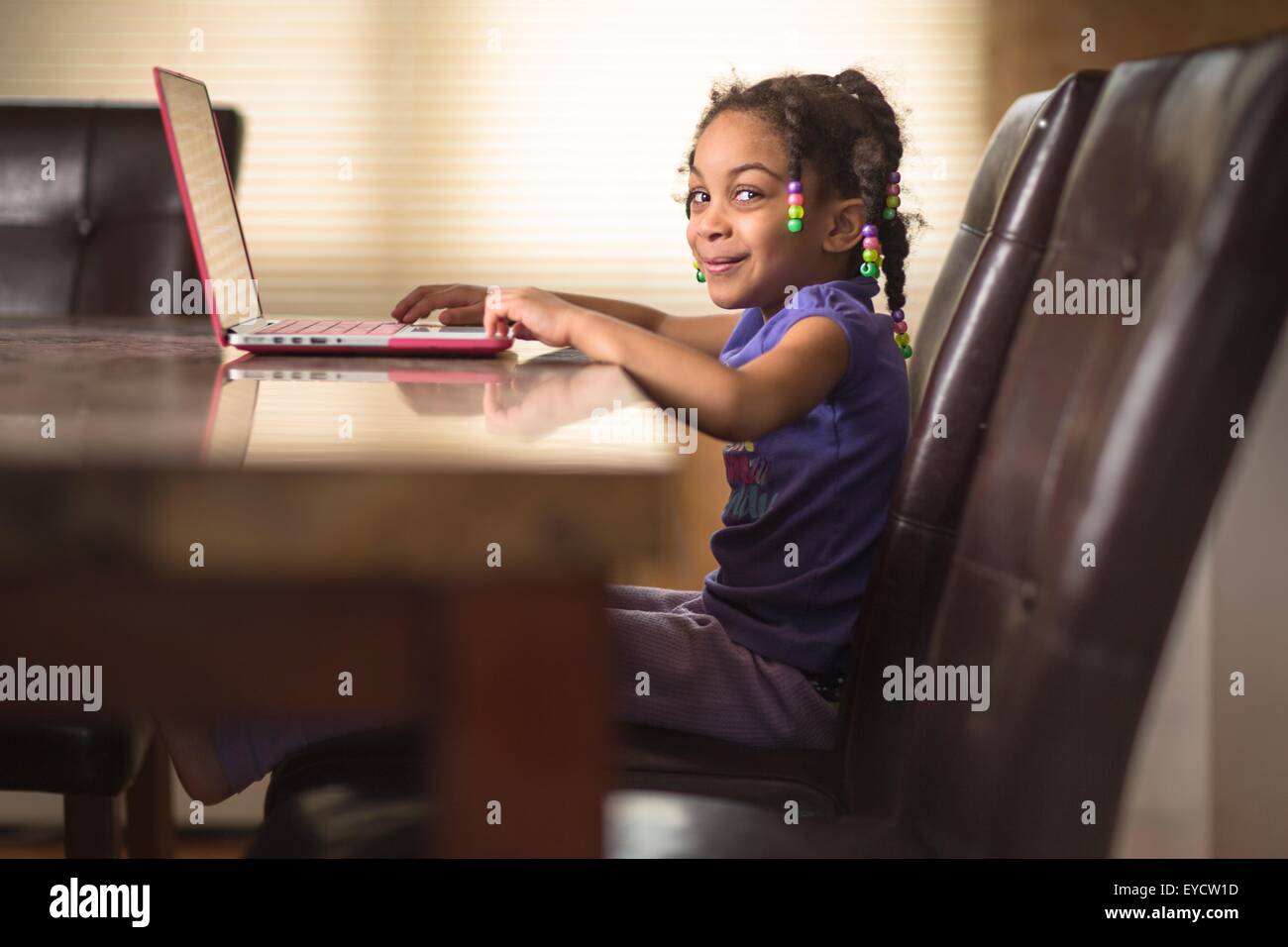 Porträt von netten Mädchen am Esstisch mit laptop Stockfoto