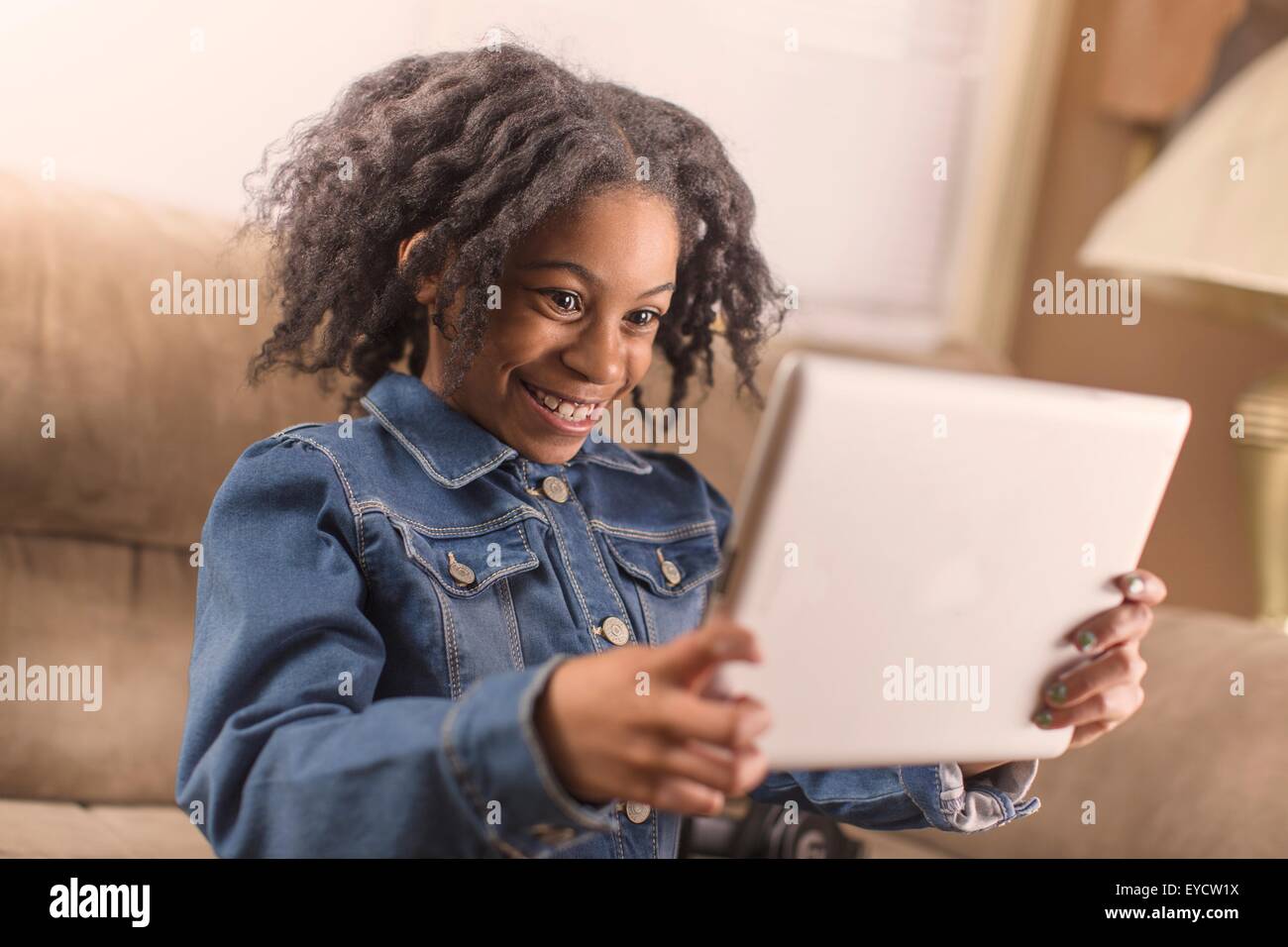 Niedliche Mädchen posieren für digital-Tablette Selfie auf sofa Stockfoto
