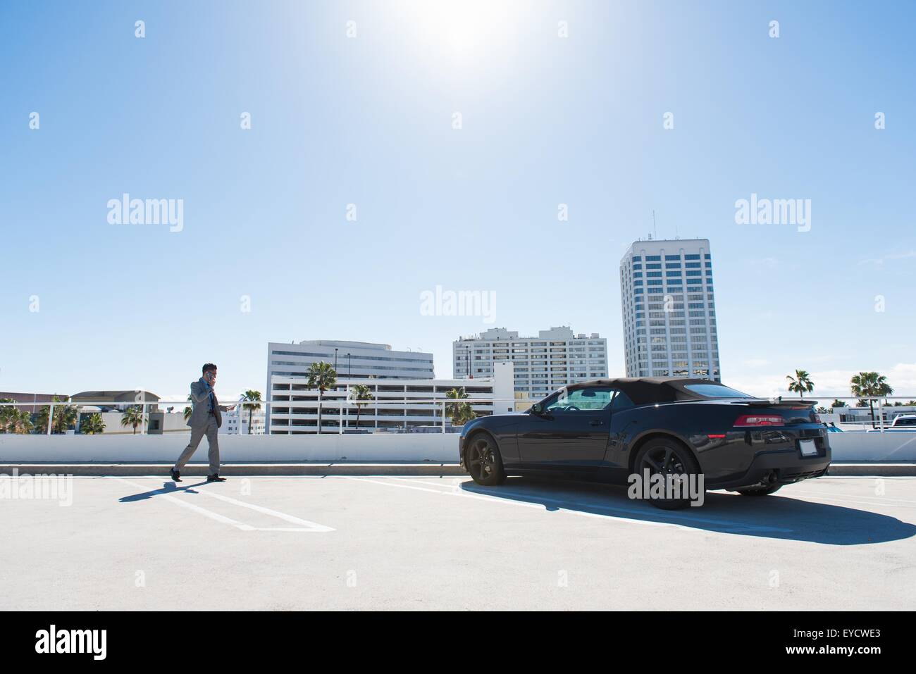Jungunternehmer am Dach Auto Stadtpark gehen und sprechen auf smartphone Stockfoto