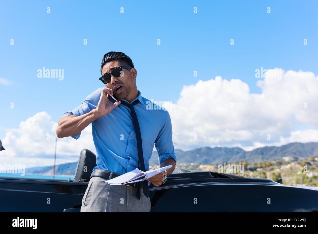 Ängstlichen jungen Geschäftsmann auf Küste Parkplatz am Smartphone sprechen Stockfoto