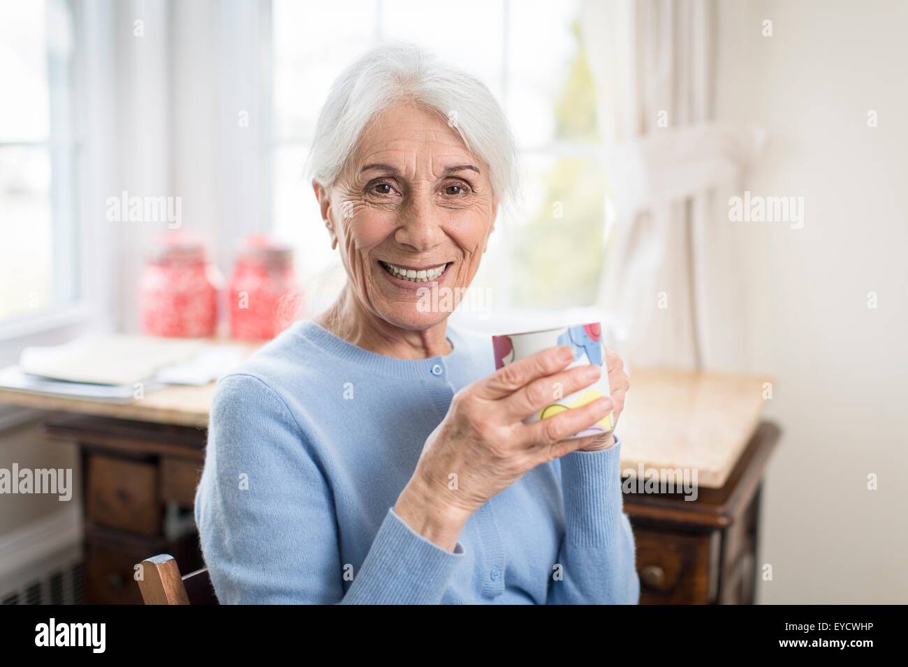 Porträt der lächelnde senior Frau halten zu Hause Tasse Stockfoto