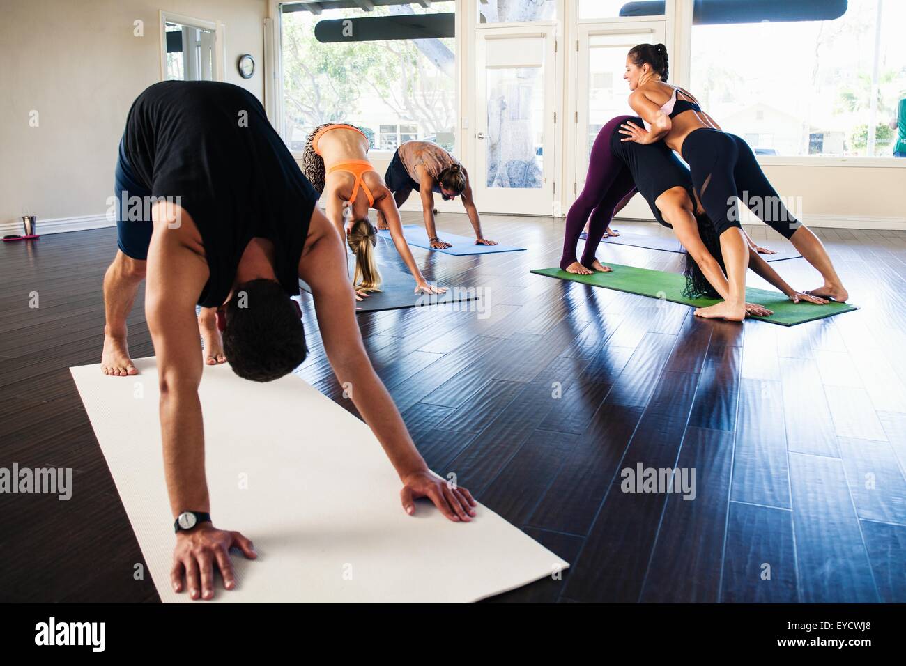 Yoga Lehrer helfen Frau in der Klasse Stockfoto