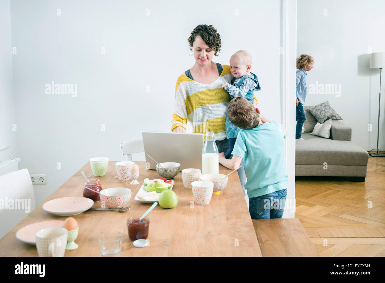 Mutter mit Laptop und seinen Kindern in Küche Stockfoto