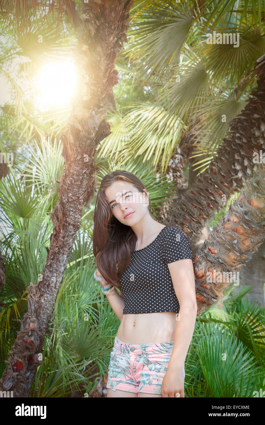 Porträt eines schönen Mädchens mit Palmen und Sonne Stockfoto