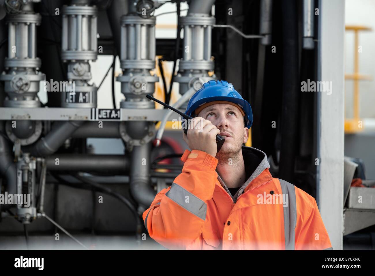 Männliche Arbeiter sprechen zwei-Wege-Radio im Tanklager Stockfoto