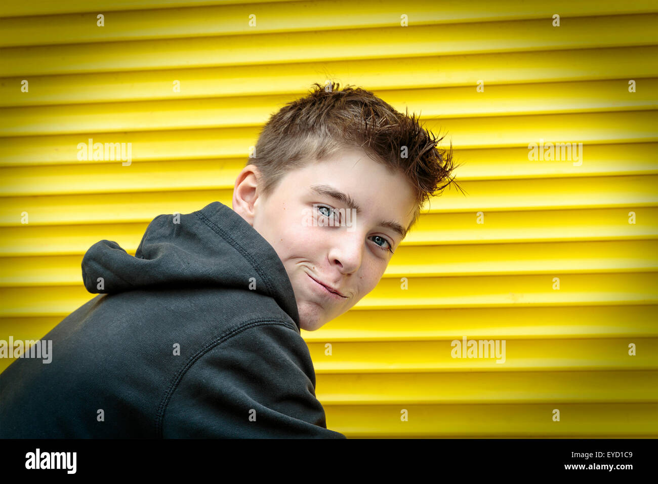 Porträt eines männlichen Jugendlichen mit gelben rolling-Shutter im Hintergrund Stockfoto