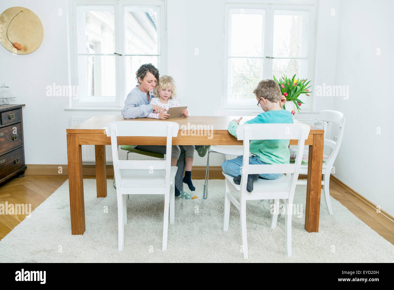 Mutter und zwei Kinder mit digitalen Tablet-PC im Wohnzimmer Stockfoto